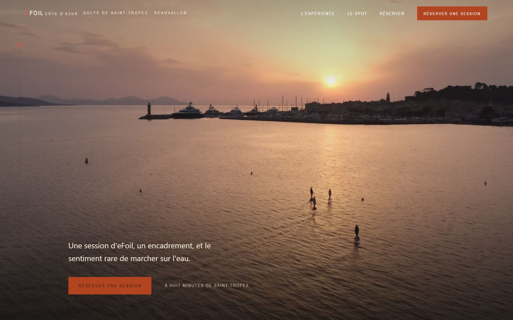 Accueil d'efoil-beauvallon.fr : vue aérienne au coucher du soleil sur le port de Saint-Tropez, quatre riders en eFoil sur l'eau, bouton Réserver une session